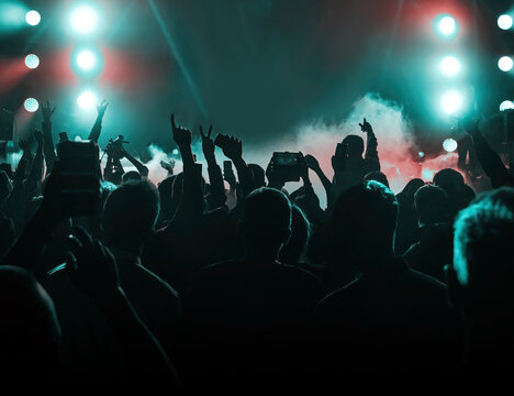 Happy crowd with raised hands at a rock concert.
