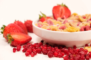 Quick breakfast of cereals and rings of corn and wheat with strawberries and lingonberries.