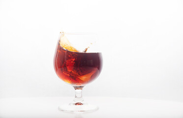 Red wine glass with ice making splash, on white background
