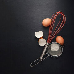 Baking background with flour, eggs, kitchen tools, utensils  on dark table. Top view. Flat lay style. Mock up.