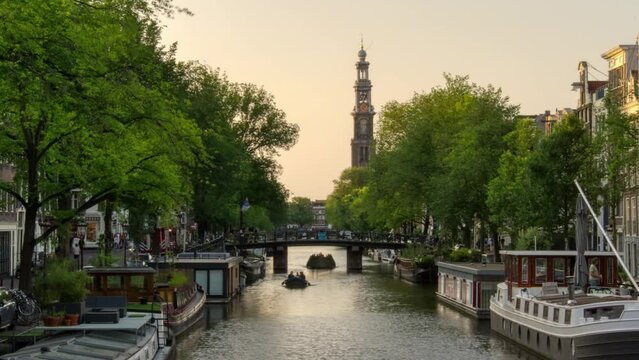 Time lapse of a canal in Amsterdam, with view of the Western church (Westerkerk), during Golden hour. Video filmed from the Prinsengracht.