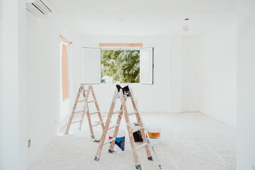 ladders and painter tools on white room at construction site. Painting walls. Home improvement, renovation