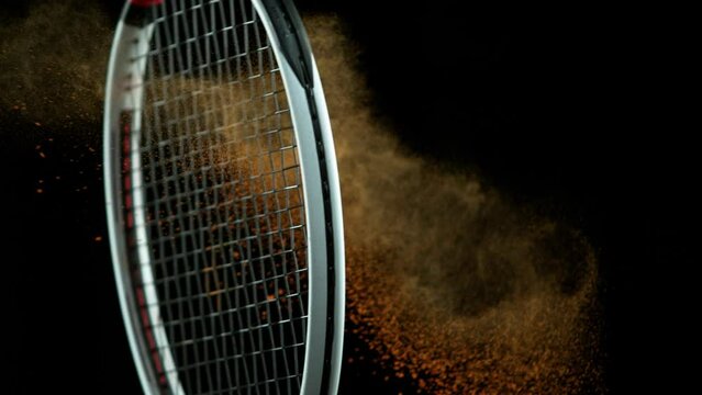 Super Slow Motion Shot of Racket Hitting Tenis Ball Containing Orange Powder at 1000 fps.