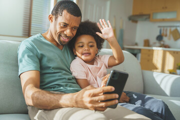 African American father and happy cute boy doing video chat on mobile phone, Black Dad and son...