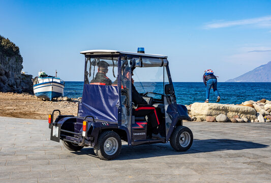 Italiensische Polizisten im E-Mobil am Hafen von Panarea, liparische Inseln, warten auf Ankunft von Fähre zur Kontrolle
