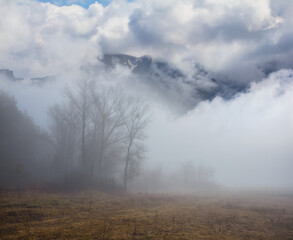 mountain valley in dense mist and clouds