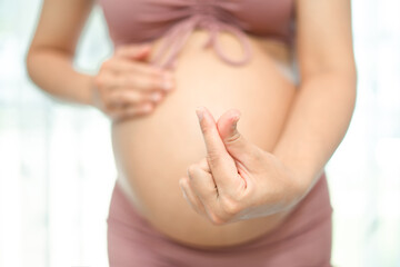 Pregnant women show their symbols by making their hands as Mini Hearts, can't see the face