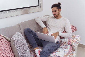 man lying on couch with his laptop