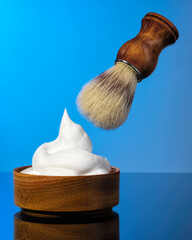 shaving brush and shaving foam on a blue background.