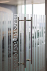 Close up of glass boardroom door with frosted privacy stripes