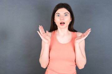 Surprised terrified young beautiful Caucasian woman Gestures with uncertainty, stares at camera,...