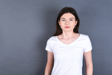 Obraz premium young beautiful Caucasian woman wearing white T-shirt over grey wall feeling confident. 
