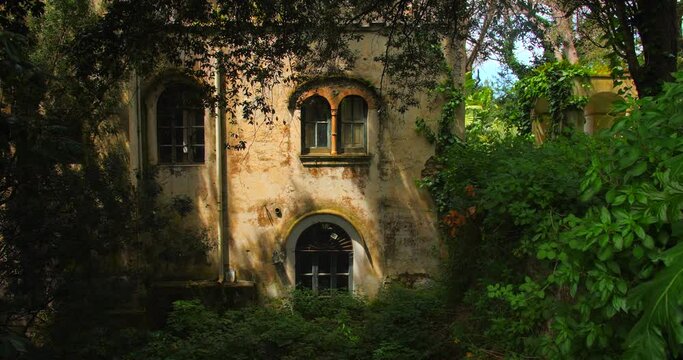 Remains Of A Historic Villa With Faded Yellow Painted Wall Exterior Surrounded By Lush Vegetation In Capri, Italy. - Pan Right Shot