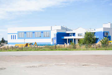 white blue building of the sports complex under construction in the summer