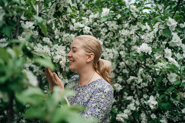 girl with blond hair in blossoming apple tree outdoor nature