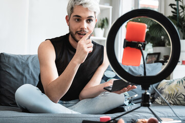 Transgender influencer streaming online makeup video tutorial on social media at home - Lgbt, gay,...