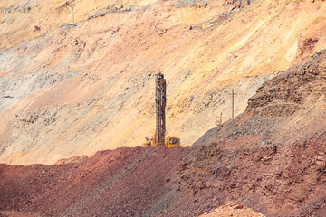 The machine for drilling wells in the quarry is standing on one of the horizons. Drilling wells for...