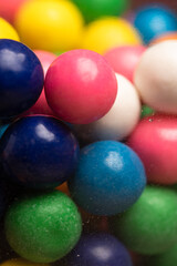 Fototapeta na wymiar Close up of multicolored gum balls, chewing gum pink blue and white in antique gum ball machine
