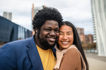 Happy young multiracial friends having fun hanging out in city