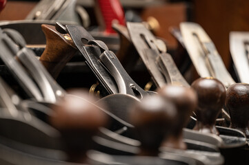 Collection of many antique vintage hand planes and woodworking tools, close up and arranged