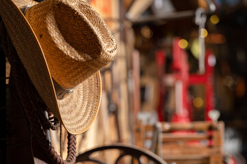 Cowboy hat hanging by wall of antique tools in a vintage barn shed