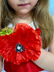 Favorite holiday dress of the girl, decorated with artificial poppy.