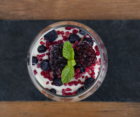 Nutrition. Top view of a trifle cup with yoghurt, white chocolate cream and red berries. 