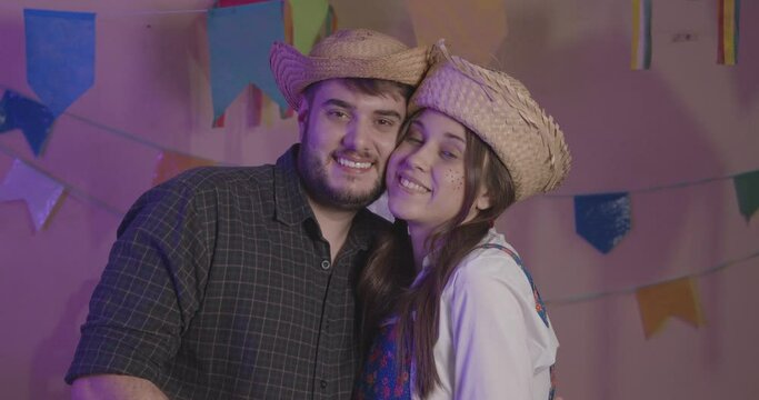 Beautiful couple wearing typical clothes for the Festa Junina. Smiling, happy. Kiss