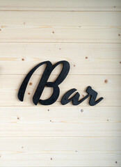 Black word sign bar on white wooden wall