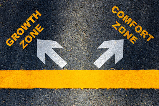 Growth and comfort zone written with white arrow sign and yellow line marking on asphalt road. Improvement concept and challenge idea
