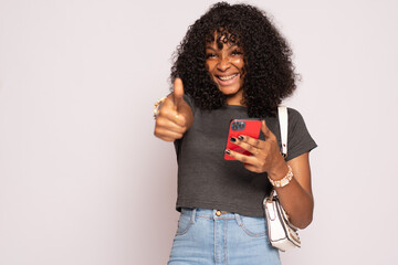 beautiful black girl holding her phone does a thumbs up