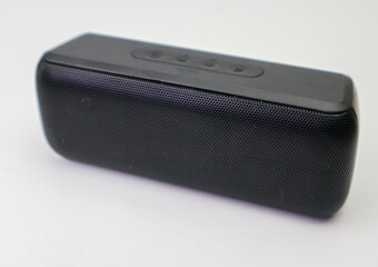 black bluetooth portable speaker in photo studio selective focus