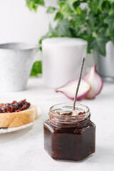 onion marmalade (Onion confiture). onion confit in a glass jar on a white background.