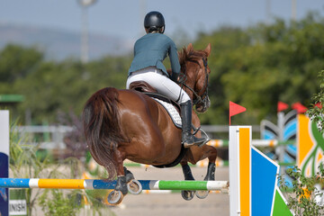 The rider on horseback overcomes the obstacle during the equestrian event