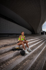 Woman in fitness wear have a rest after workout with a heavy medicine ball and trx straps...