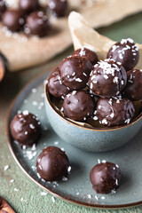 Vegan chickpea and peanut butter candies in chocolate glaze sprinkled with coconut chips. Energy balls. Healthy raw dessert without sugar.