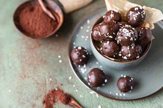 Vegan chickpea and peanut butter candies in chocolate glaze sprinkled with coconut chips. Energy balls. Healthy raw dessert without sugar.