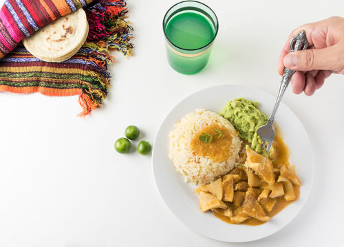Tiras, plato t&iacute;pico tradicional de guatemala hecho con panza de res en una salsa de miltomate en el caso de esta foto, que se acompa&ntilde;a con arroz y guacamol y tortillas de ma&iacute;z