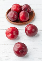 A group of plums over wooden table