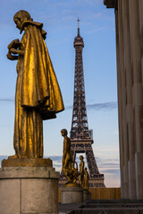 Tour Eiffel au coucher du soleil derrière les statues du Palais Chaillot - obrazy, fototapety, plakaty