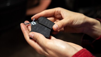 Fototapeta premium Hand holding new car brake pads. Replacing car brake pads. Change the old to new brake disc on car in a garage. Auto repair concept.