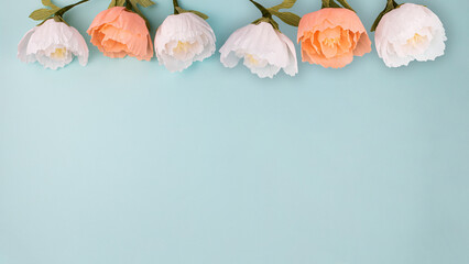 Hand made crepe paper peonies on blue background flat lay 16:9. Paper peony DIY concept - obrazy, fototapety, plakaty