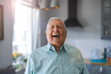 Happy senior man laughing in his home
