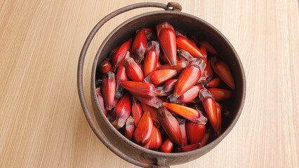 Black iron pan with pine nuts inside. Wood background. Traditional Brazilian winter food. Typical...