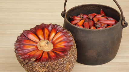 Black iron pot with pine nuts inside and a ball of pine nuts on the side. Wooden background....