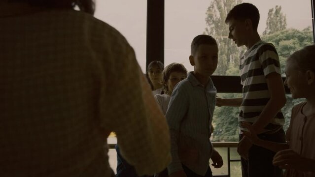 Aggressive students pushing conflict victim in hallway. Bullies insulting boy.