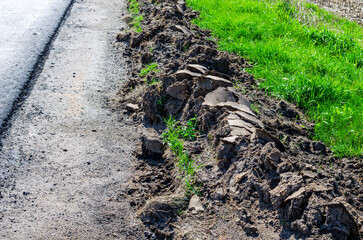 Cleaning the side of the road from sand with a grader