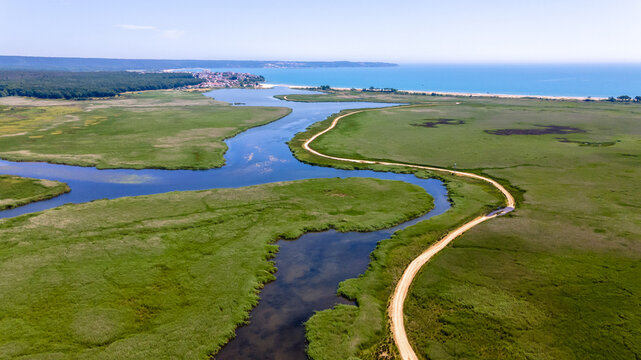 Drone view of Mert Lake and Black Sea coast in Igneada. A lake curled through the reeds.