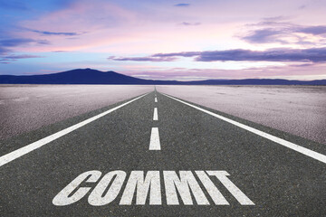 The word Commit written on a highway for commitment and dedication concept.