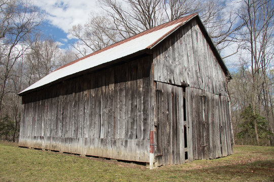 old barn with metal roof in the field